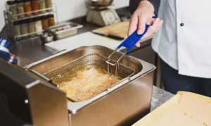 Smażenie we frytownicy kurczak w panierce w amerykańskim stylu